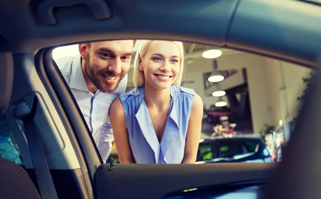 Couple discussing auto sales paperwork