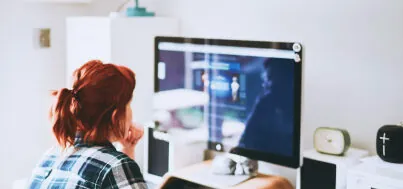 Person sitting, looking at a computer screen