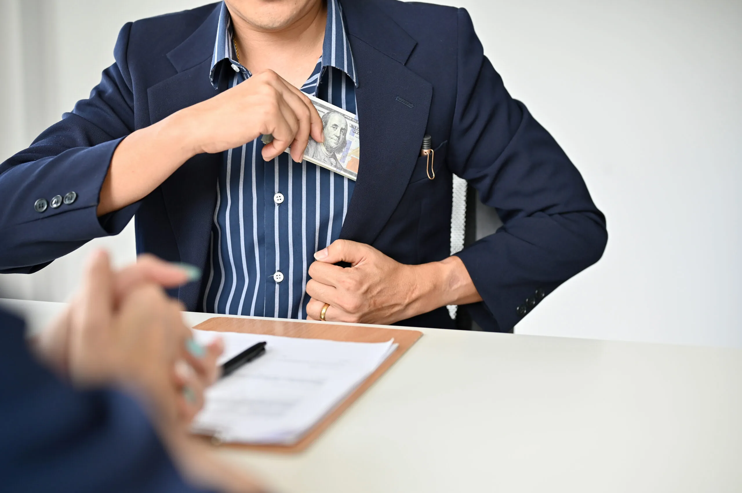 An Asian businessman in the meeting with his personal lawyer to pay a legal consultation fee.