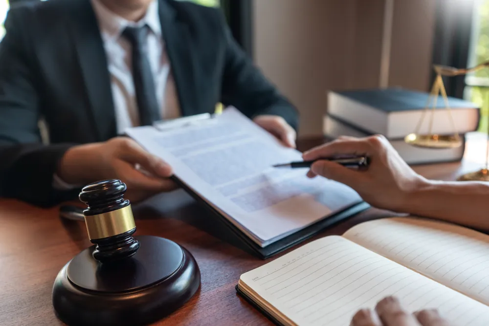 Judge with gavel and out of focus contract being shown to someone taking notes