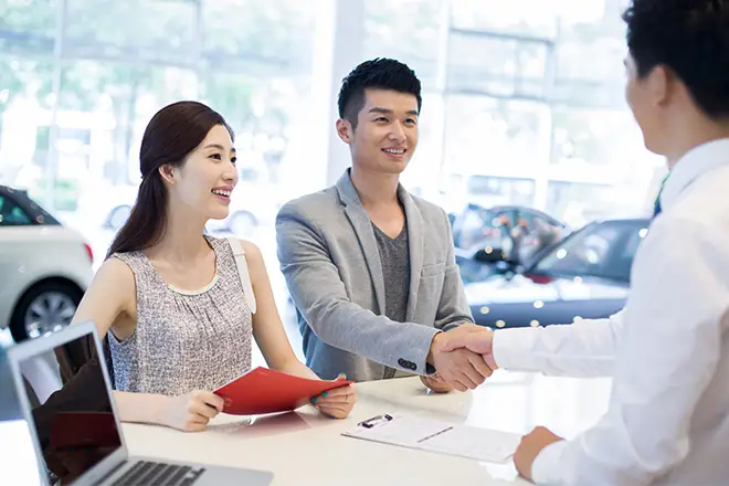Salesperson helping a couple purchase a vehicle