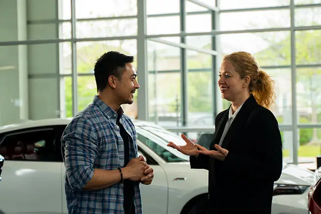 Salesperson helping a couple purchase a vehicle